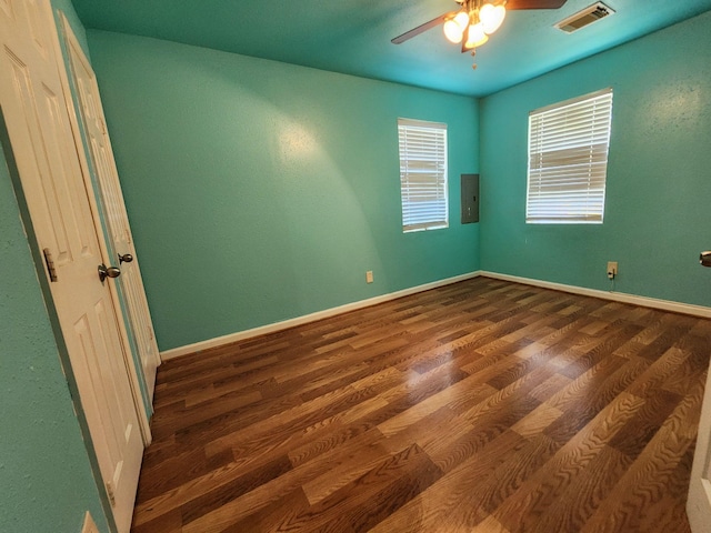 unfurnished room with ceiling fan, dark hardwood / wood-style flooring, and electric panel