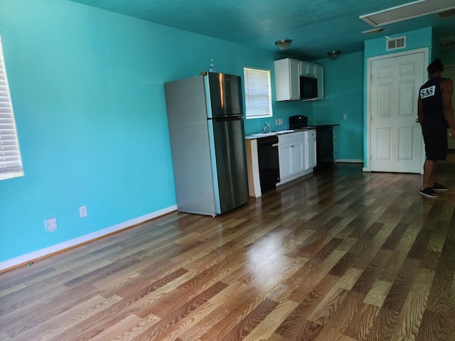 kitchen featuring white cabinets, hardwood / wood-style flooring, stainless steel fridge, and dishwasher