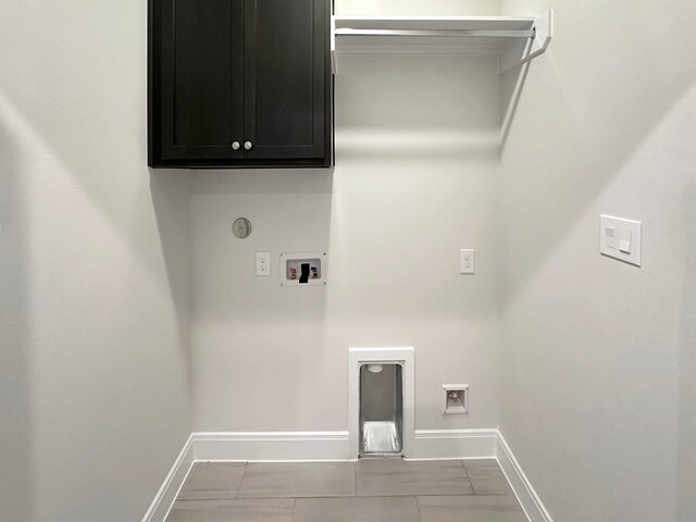 clothes washing area featuring washer hookup, light tile patterned floors, cabinets, and electric dryer hookup