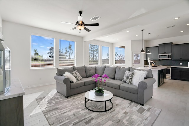 living room featuring ceiling fan, sink, and light hardwood / wood-style floors