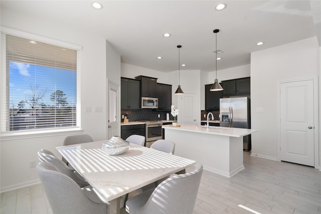 dining space with sink and light hardwood / wood-style flooring