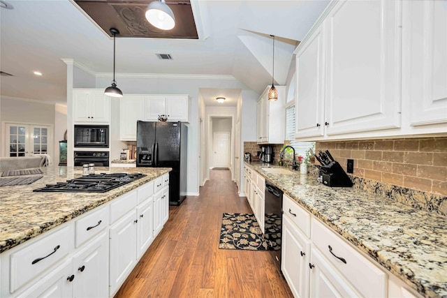 kitchen with white cabinetry, sink, hanging light fixtures, black appliances, and light wood-type flooring