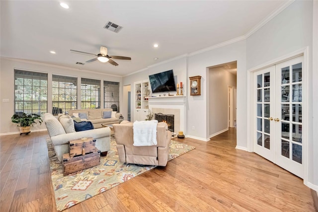 living room featuring french doors, ceiling fan, ornamental molding, and light hardwood / wood-style floors