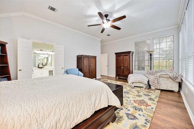 bedroom featuring ceiling fan, ornamental molding, connected bathroom, and light hardwood / wood-style floors