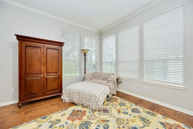 sitting room with hardwood / wood-style floors and crown molding