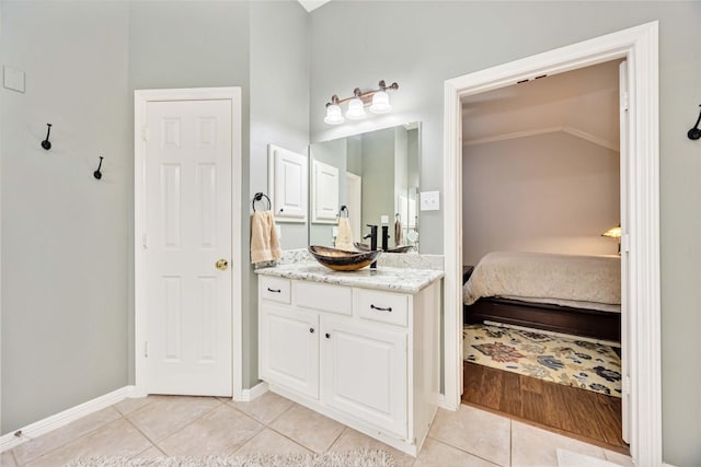 bathroom with tile patterned flooring, vanity, and vaulted ceiling