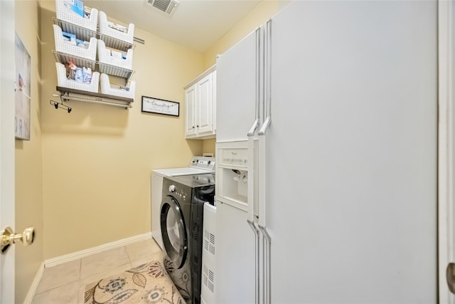 laundry area featuring cabinets, washing machine and clothes dryer, and light tile patterned floors