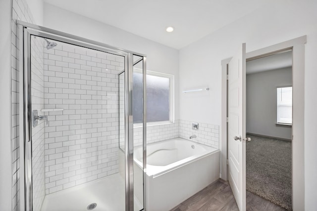 bathroom featuring independent shower and bath and hardwood / wood-style flooring