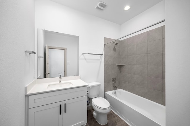 full bathroom featuring vanity, hardwood / wood-style flooring, toilet, and tiled shower / bath