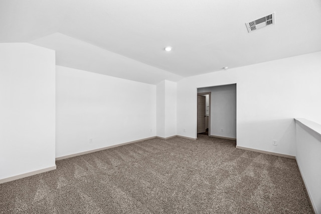 carpeted empty room with lofted ceiling