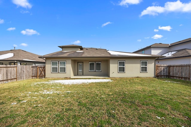 rear view of house featuring a lawn and a patio