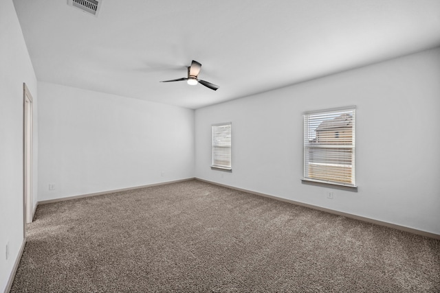 carpeted spare room featuring ceiling fan