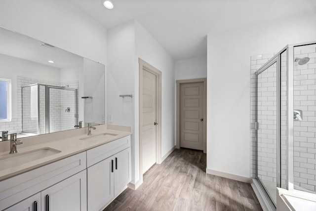 bathroom featuring a shower with door, vanity, and hardwood / wood-style flooring