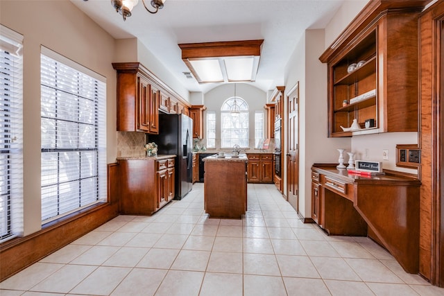 kitchen featuring vaulted ceiling, a center island, stainless steel fridge with ice dispenser, and light tile patterned floors