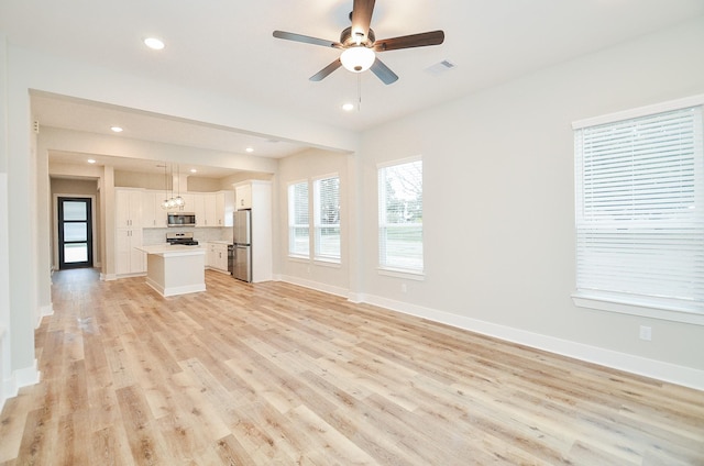 unfurnished living room featuring ceiling fan and light hardwood / wood-style flooring