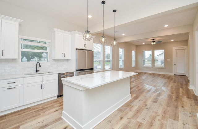 kitchen featuring sink, a center island, refrigerator, dishwasher, and white cabinets