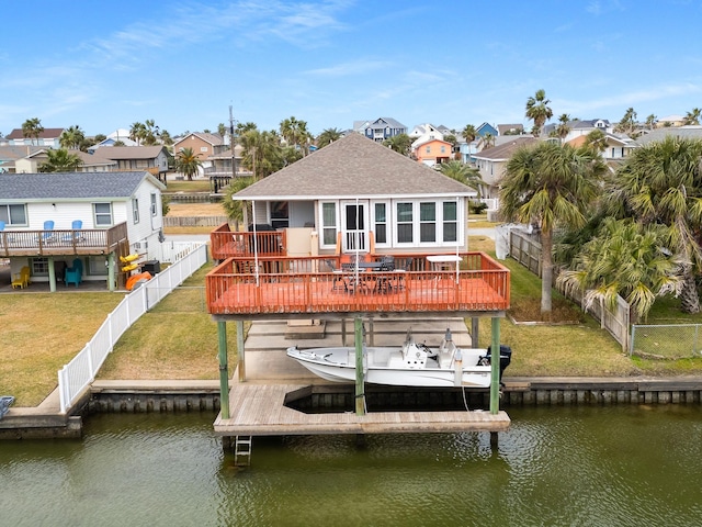 view of dock with a water view and a lawn