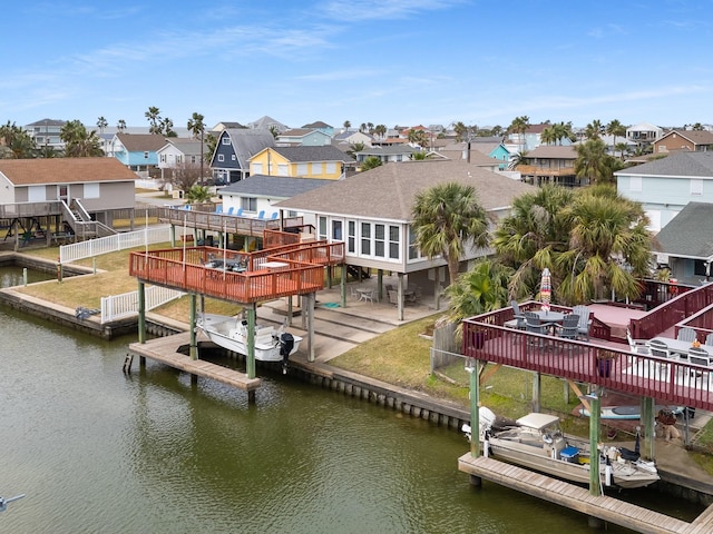 view of dock featuring a deck with water view and a yard