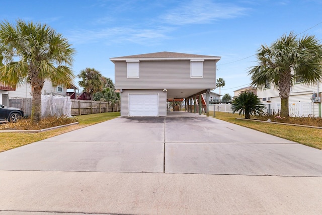 view of front of property featuring a carport, a garage, and a front lawn