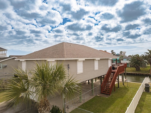 16527 Nassau Way, Jamaica Beach, TX 77554 - back of house featuring a water view, stairs, a fenced backyard, a lawn, and a shingled roof