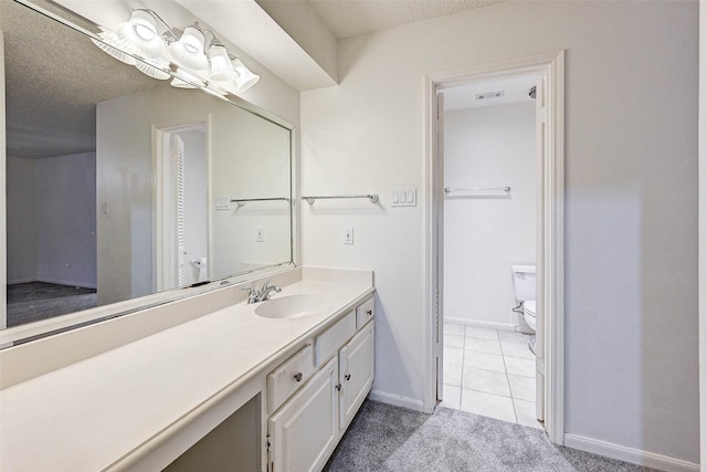 bathroom with vanity, toilet, tile patterned flooring, and a textured ceiling