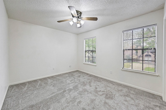 spare room featuring a textured ceiling, light colored carpet, and ceiling fan