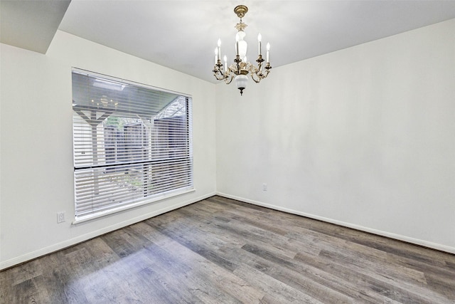 unfurnished room with a notable chandelier and hardwood / wood-style flooring