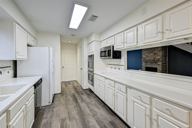 kitchen featuring backsplash, white cabinets, and appliances with stainless steel finishes