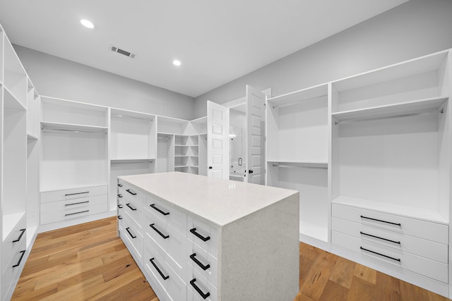 spacious closet with light hardwood / wood-style flooring