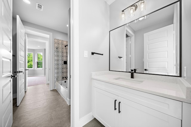 bathroom featuring tiled shower / bath and vanity