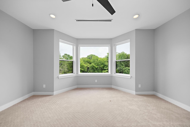 spare room featuring ceiling fan and light carpet