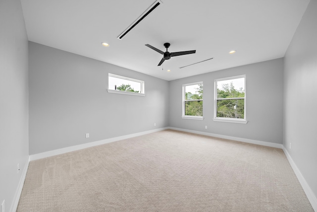 carpeted spare room featuring ceiling fan and plenty of natural light