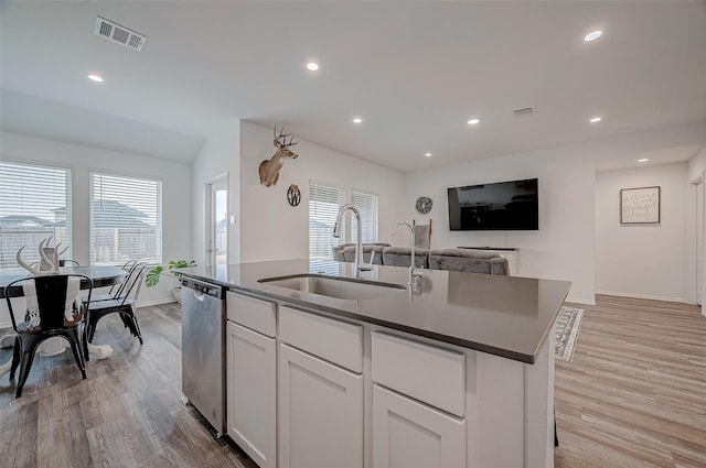 kitchen with white cabinetry, sink, stainless steel dishwasher, a center island with sink, and light hardwood / wood-style flooring