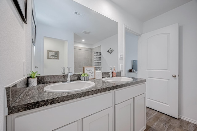 bathroom featuring a tile shower, vanity, and hardwood / wood-style flooring