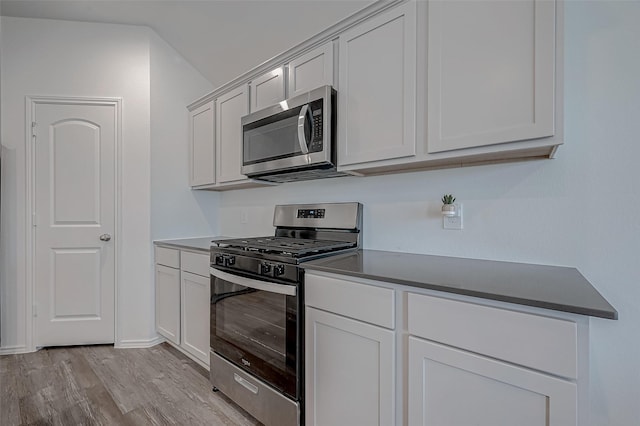 kitchen featuring stainless steel appliances, white cabinetry, and light hardwood / wood-style flooring