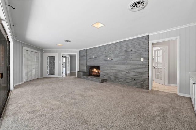 unfurnished living room featuring ornamental molding, light carpet, and a brick fireplace