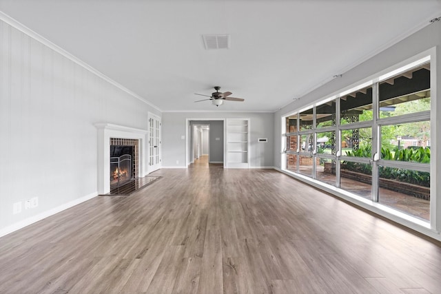 unfurnished living room with hardwood / wood-style floors, built in shelves, ornamental molding, and ceiling fan