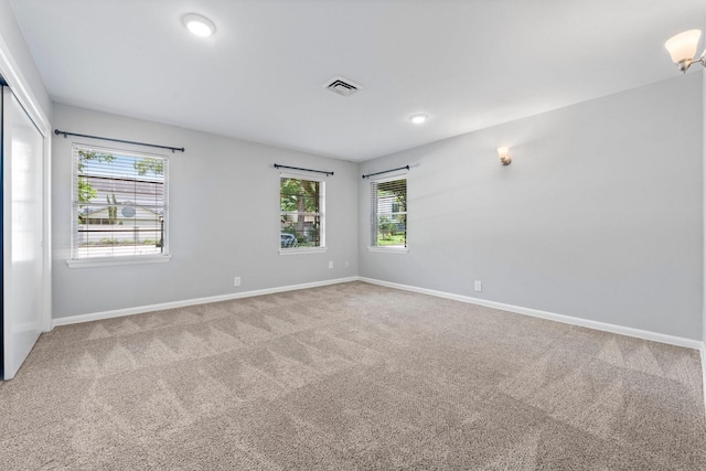 empty room with a healthy amount of sunlight and carpet flooring