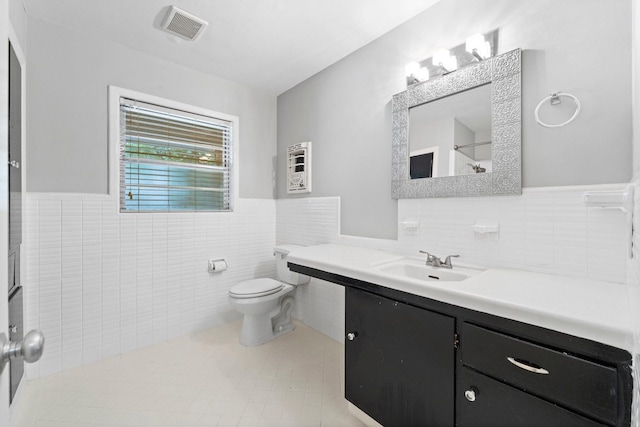 bathroom featuring tile walls, vanity, and toilet