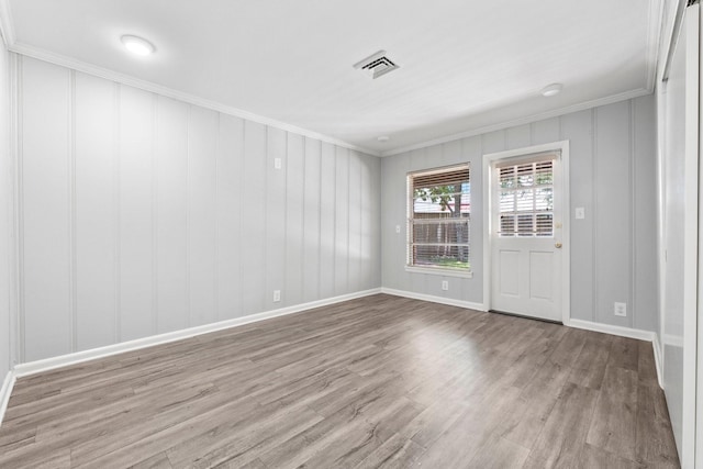 unfurnished room with crown molding and light wood-type flooring