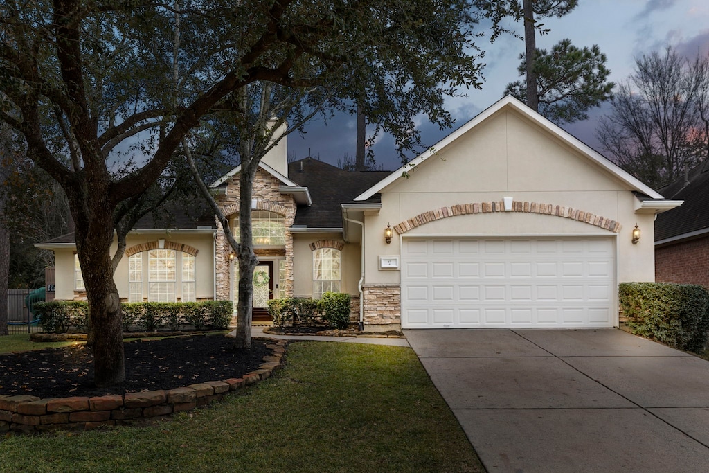 ranch-style home featuring a garage and a lawn