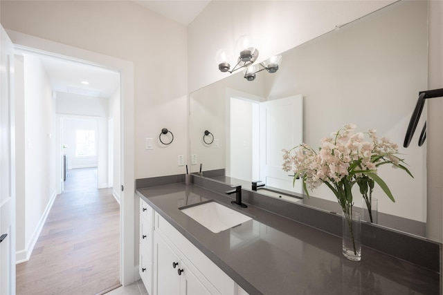 bathroom featuring a notable chandelier, wood-type flooring, and vanity