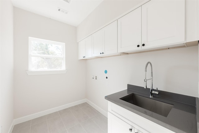 washroom with sink, hookup for a washing machine, cabinets, and light tile patterned floors