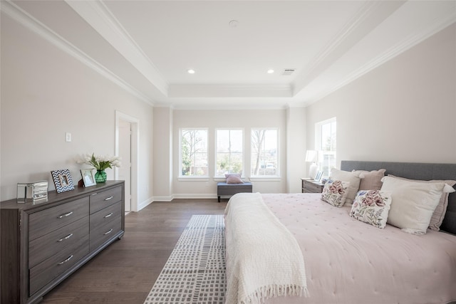 bedroom with dark hardwood / wood-style floors, ornamental molding, and a tray ceiling