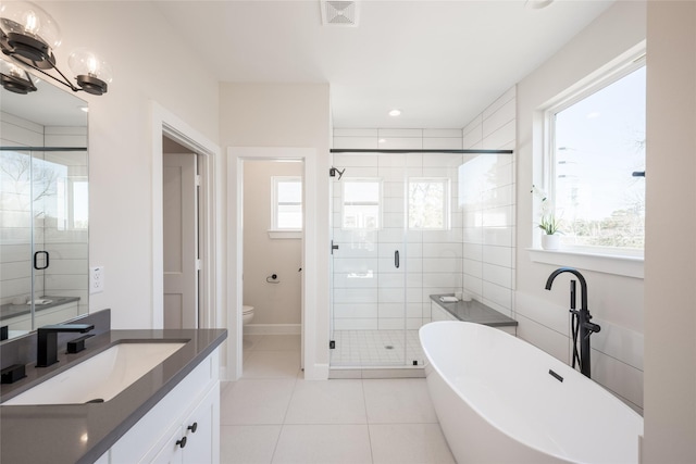 full bathroom featuring tile patterned floors, a healthy amount of sunlight, toilet, and vanity