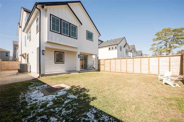 rear view of house with a yard and central AC unit