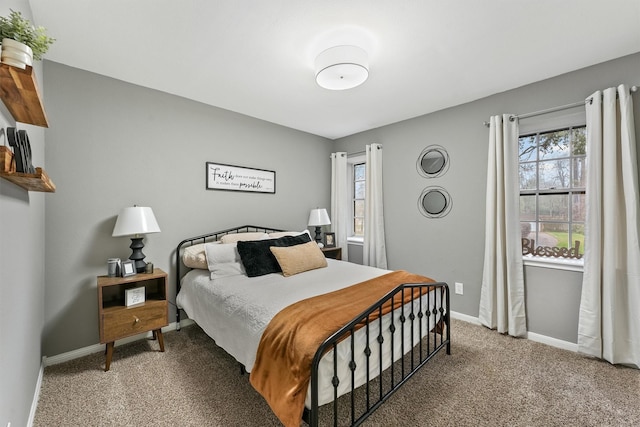 carpeted bedroom featuring multiple windows and baseboards