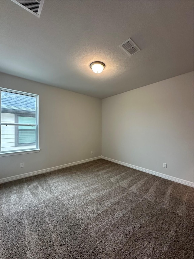 carpeted spare room featuring a textured ceiling