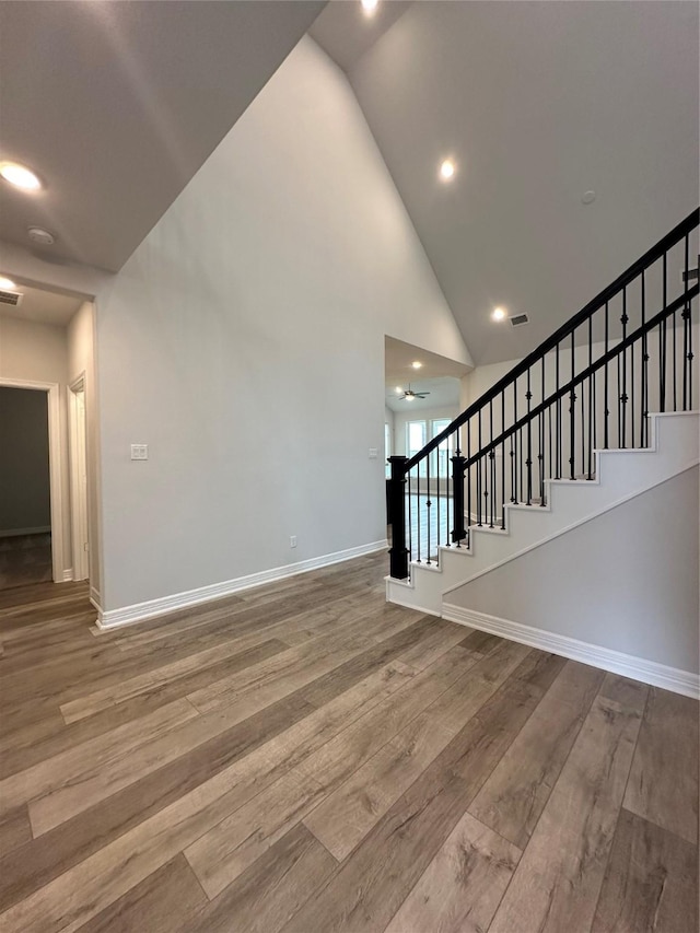 interior space with wood-type flooring and high vaulted ceiling