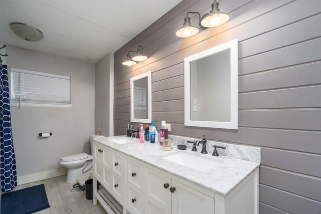 bathroom featuring vanity, toilet, hardwood / wood-style floors, and wood walls